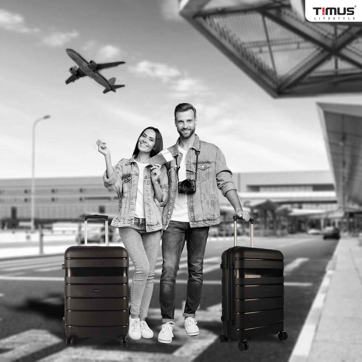 A man and woman standing at the airport holding black Sunlite hard trolley bags, showcasing a travel-ready lifestyle with stylish luggage.