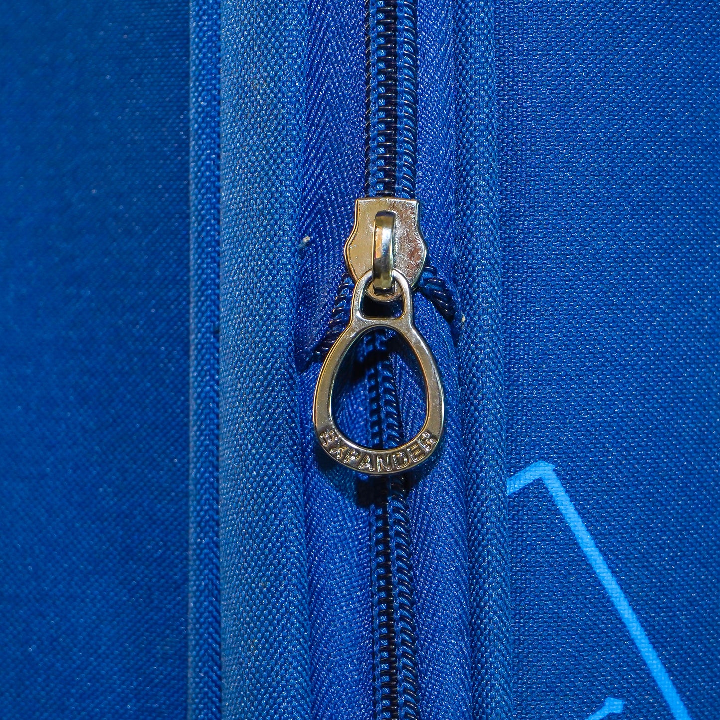 Expandable zipper chain on blue Flash Plus luggage to increase capacity