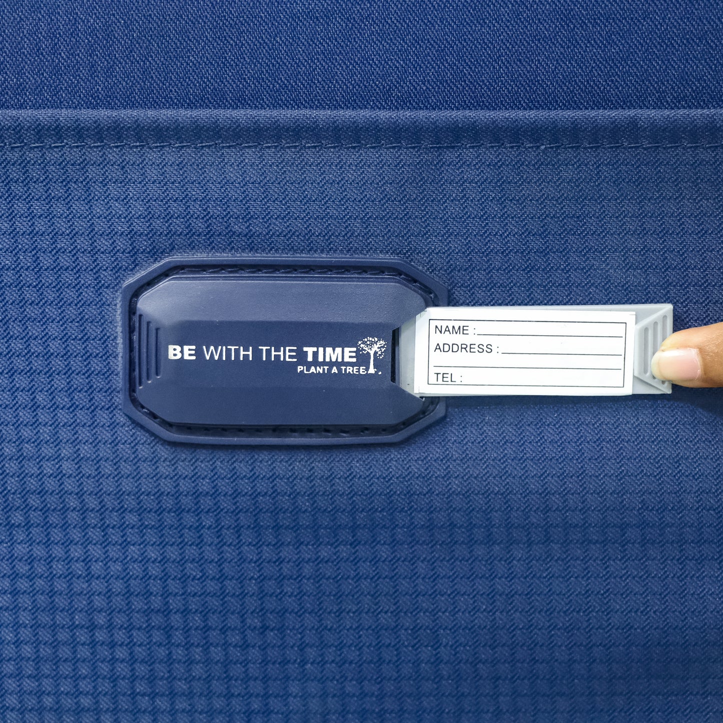 Close-up of the name tag on navy blue Salsa Plus luggage with the identification card visible, allowing easy personalization for secure travel.
