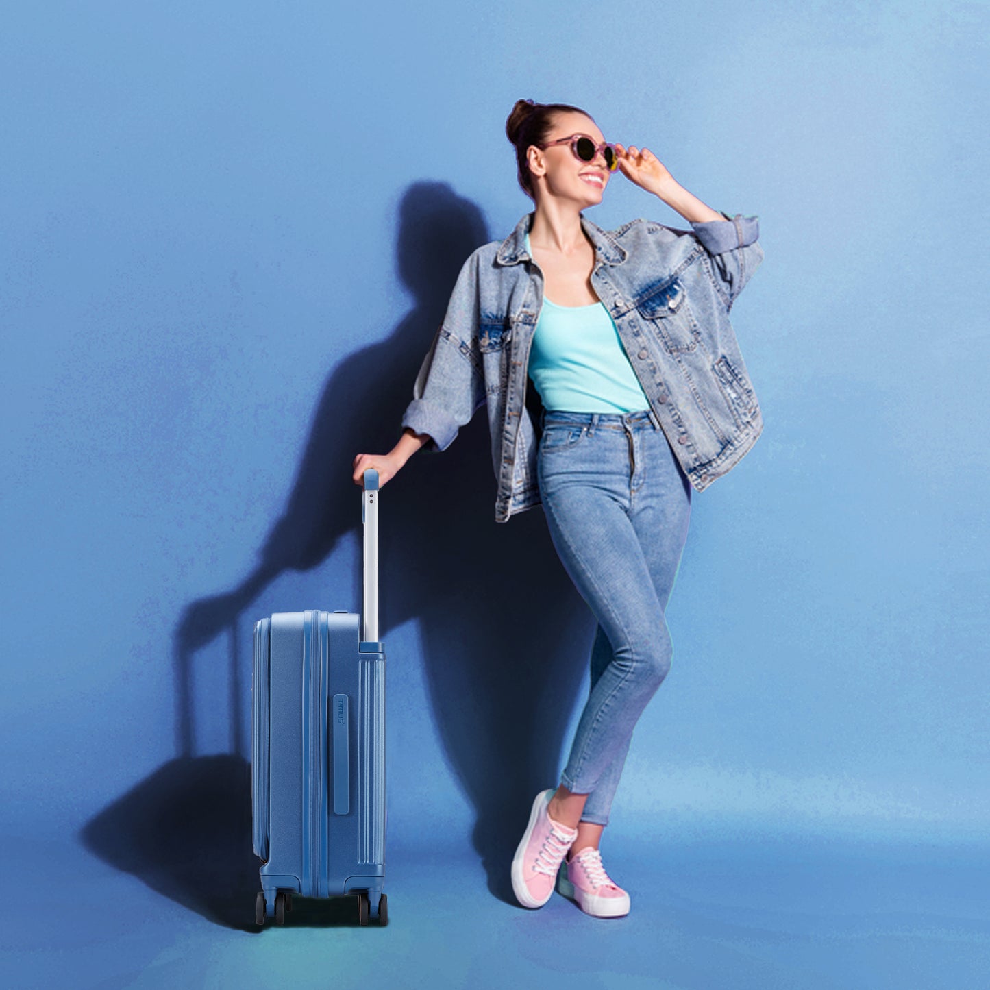 Model carrying Timus Starlite blue luggage showcasing stylish and lightweight travel design.