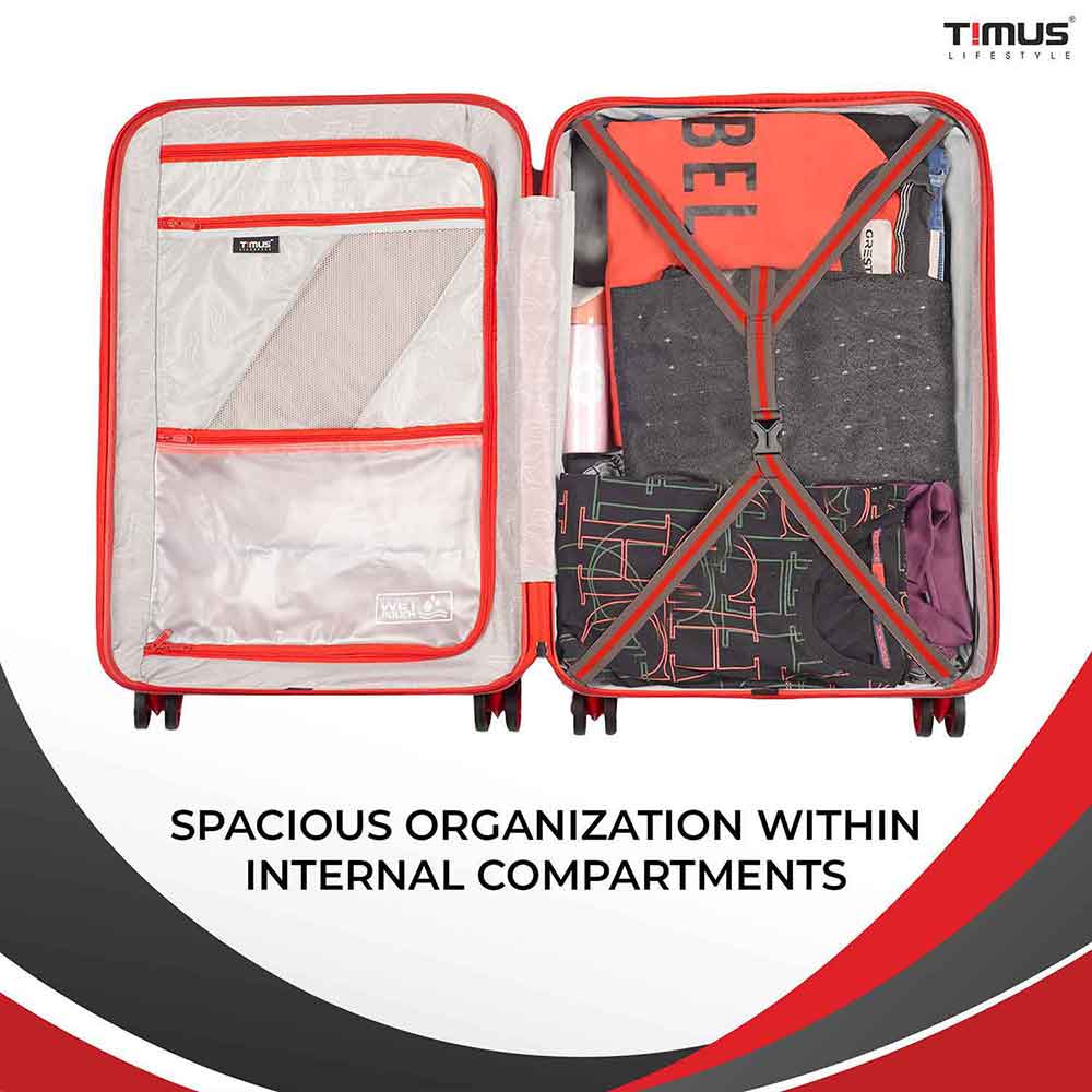 Open view of red sunlite hard trolley bag showing neatly packed clothes with straps on one side and closed zippered compartment on the other, highlighting spacious and organized interior.