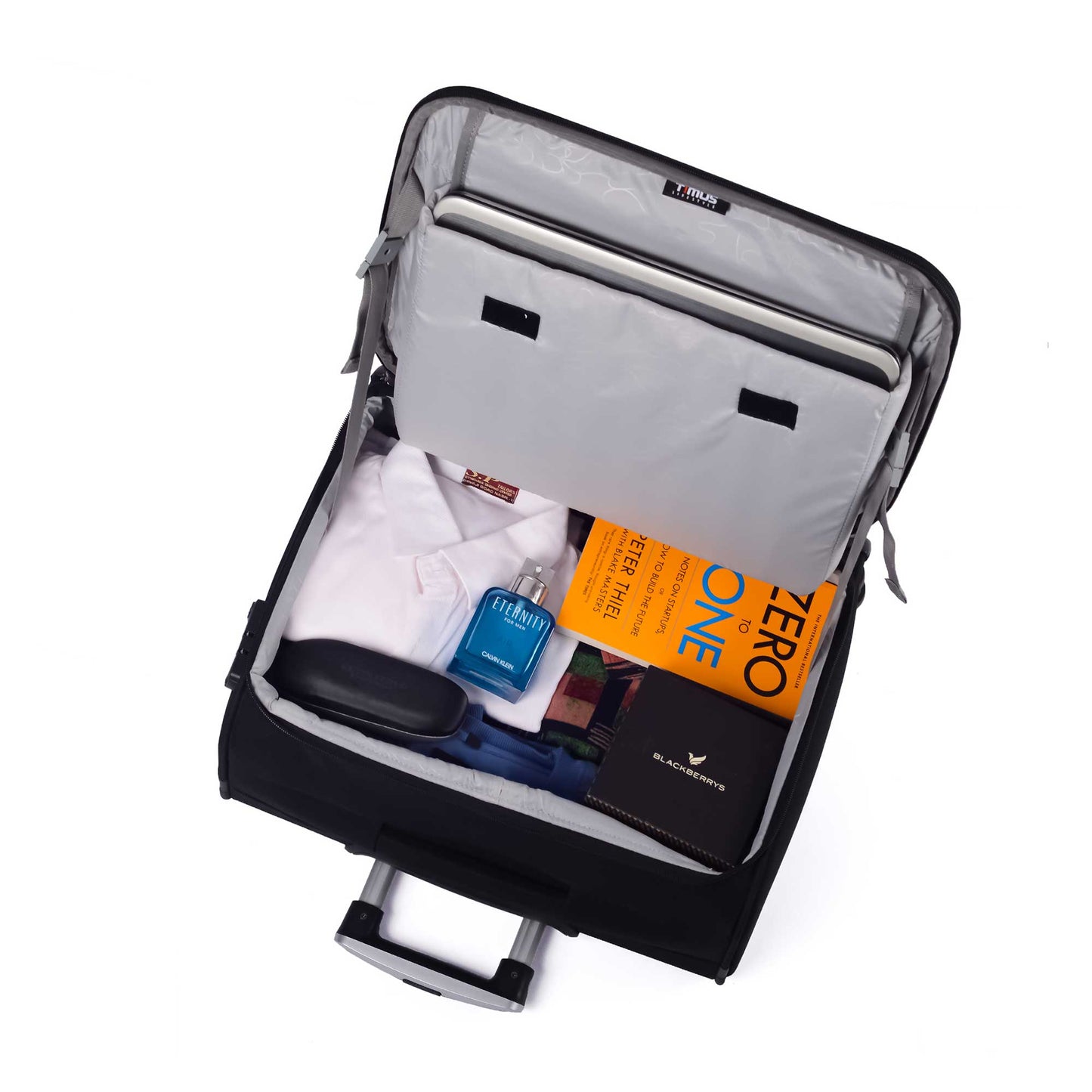 Top interior view of Timus Atlanta Pro Overnighter black business travel bag showcasing organized compartments with packed clothes, book, perfume, laptop, and documents; visible padded laptop sleeve and elastic garment straps with timus tag.