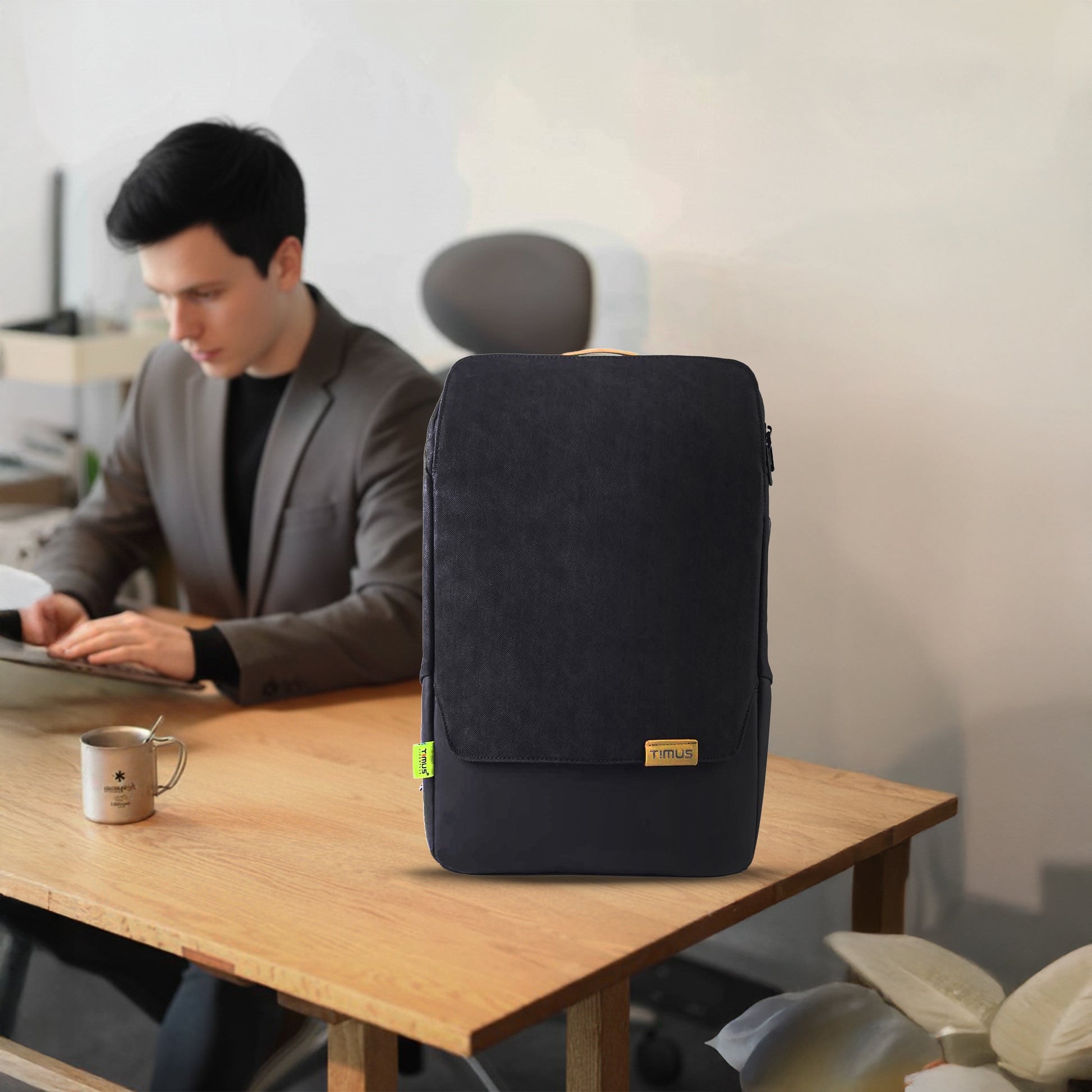 Professional seated outdoors with Timus Magnet Overnighter black backpack, highlighting its modern office look, lightweight comfort, and travel-ready design.