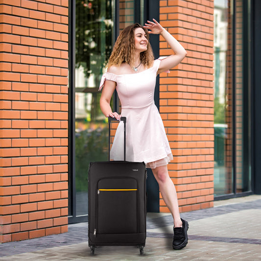Lifestyle shot of Timus Nexon black luggage beside a traveller, showcasing stylish, practical, and versatile design for modern journeys