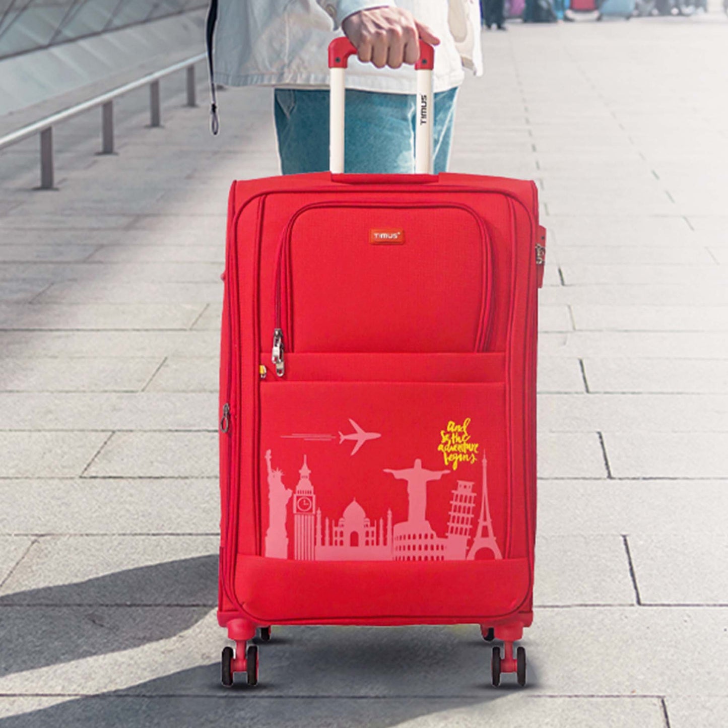 Red suitcase with travel-themed design on a pavement