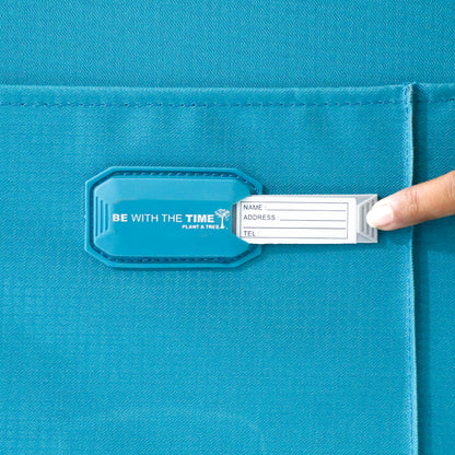 Close-up of the name tag slot on blue Salsa Plus luggage with the name card slightly visible for easy identification.