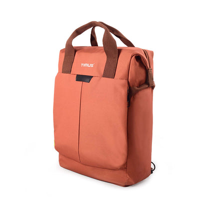 Left side front angled view of rust Timus Chicago urban backpack showing brown handles and front pocket.