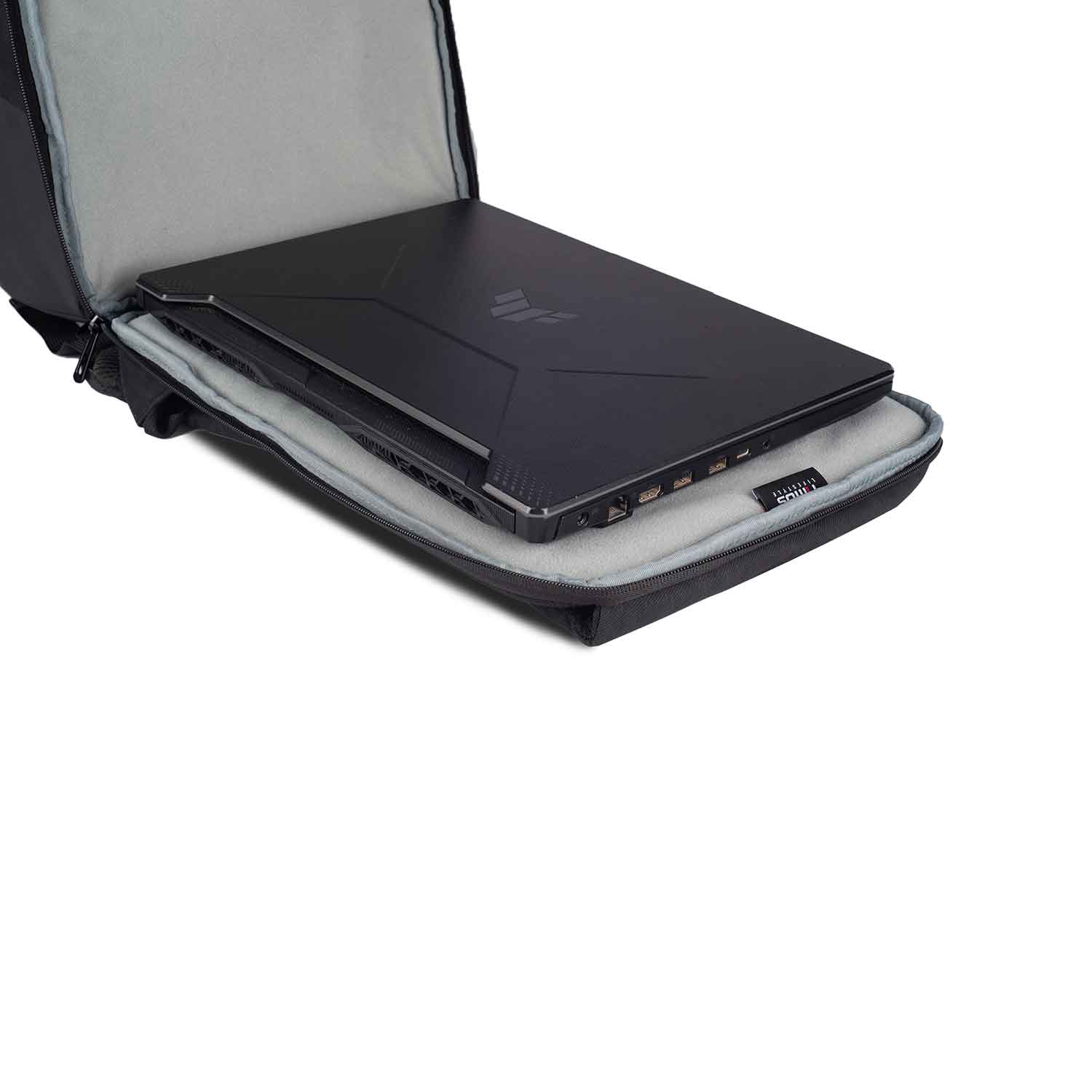 Close-up view of the Timus Magnet Overnighter backpack open flat with a black laptop inside its padded, grey fabric-lined laptop compartment.