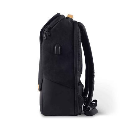 Left side view of the Timus Magnet Overnighter backpack in black, showing the padded shoulder straps, a USB charging port on the side, and a leather top handle. The bag is standing upright on a white background.