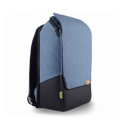 Right front angled view of the Timus Magnet Overnighter backpack in blue with the front flap closed, showing its sleek, minimalist design and green brand tag at the bottom.
