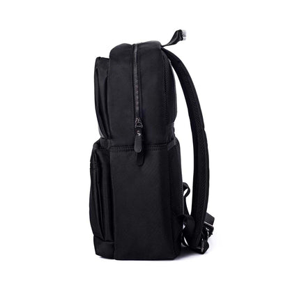 Left side view of Timus Oslo black professional laptop backpack showing padded straps, zippered compartments, and sleek minimalist side design.
